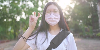 亚洲少女在口罩后微笑的肖像在新冠肺炎疫情