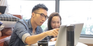 亚洲华人室友在家里使用笔记本电脑聊天