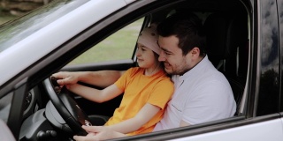 父亲和女儿坐在汽车的方向盘后面。