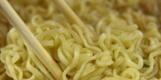 方便面和中国筷子混合在一起。酿造黄色拉面特写