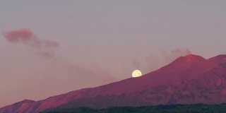 黎明时分，意大利西西里岛的埃特纳火山喷发，背景是超级月亮