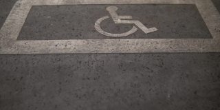 一辆空轮椅停在为残疾人准备的停车场里。在购物中心附近的人行道上为残障汽车标出的特殊位置。