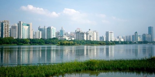 在中国南宁，荷塘前的城市景观与湖反射。