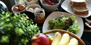 健康的早餐，水果橙，草莓，蔬菜，香蕉，鸡蛋，烤面包，酸奶苹果和果酱在餐桌上