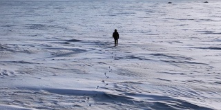鸟瞰图:一个孤独的人走过雪地