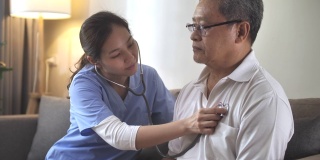 亚洲护士在家为一位老年病人检查听诊器