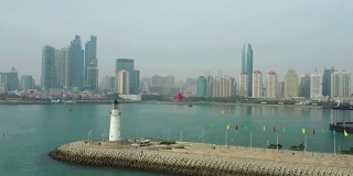白天青岛市区海岸线湾纪念碑灯塔码头观看4k中国航拍全景图