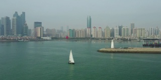 白天青岛市区海岸线湾纪念碑帆船驶过灯塔码头航拍4k中国全景
