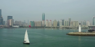 白天青岛市区海岸线海湾纪念碑帆船航行航拍全景4k中国