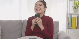 快乐美丽的亚洲女人网上购物通过智能手机应用程序，电子商务技术和亚洲的生活方式