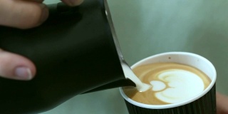咖啡师把牛奶倒进咖啡里。