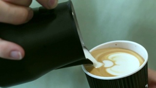 咖啡师把牛奶倒进咖啡里。视频素材模板下载