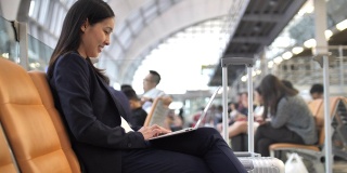 亚洲女商人在机场休息室使用笔记本电脑工作