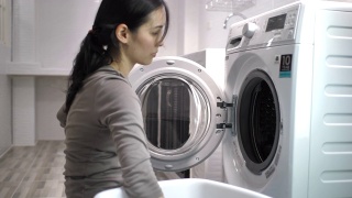 亚洲女人用洗衣机洗衣服视频素材模板下载