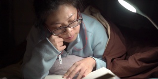 2多莉拍摄的亚洲妇女晚上在床上看书