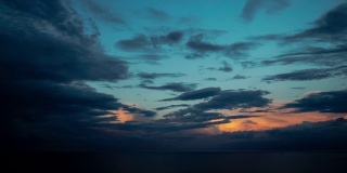 空中缩小云景多云的天空时间流逝在密歇根湖的水作为风暴吹过黄昏之前，太阳在蓝色的天空上创造橙色的云。
