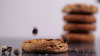美味的巧克力饼干在黑暗的背景下以慢动作落下视频素材模板下载