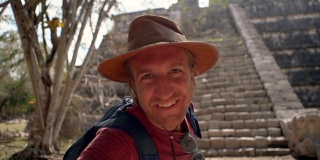 一名男子在墨西哥古玛雅金字塔附近自拍的慢动作视频，人们旅行个人视角的概念。男人分享视频聊天朋友快乐的周游世界