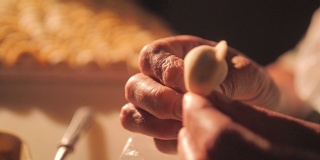 厨师用面团做饺子。他的手的特写