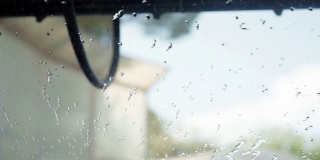 汽车沿着洗车隧道行驶，水滴落在挡风玻璃上，自动洗车机。在汽车维修中，对汽车进行全面清洗后，对汽车外观进行干燥