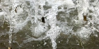 慢镜头镜头上喷泉的水滴和飞溅在空中。城市公园喷泉工作。