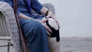 特写镜头老年白人妇女的膝关节关节炎疼痛在正午户外在夏天视频素材模板下载