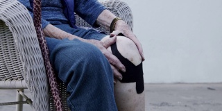 特写镜头老年白人妇女的膝关节关节炎疼痛在正午户外在夏天