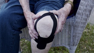 特写镜头老年白人妇女的膝关节关节炎疼痛在正午户外在夏天视频素材模板下载