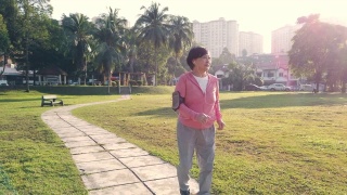 一位华裔老年妇女在公园晨练，在人行道上跑步视频素材模板下载