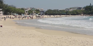 游客在石澳海滩享受海浪，一段白沙在香港岛-宽镜头