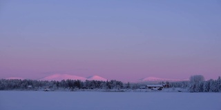 黄昏时分，芬兰，拉普兰红色建筑的全景，靠近白雪覆盖的森林