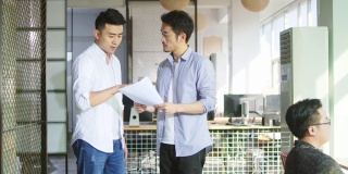 两位亚洲企业家在办公室里讨论