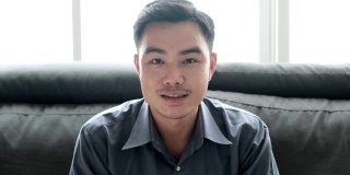 亚洲男子教师通过笔记本电脑视频会议或视频电话他在家工作时对他的学生微笑与冠状病毒或COVID - 10情况。