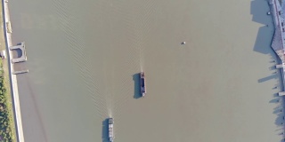 不断上升的无人机拍摄到内河运输线上的货船。