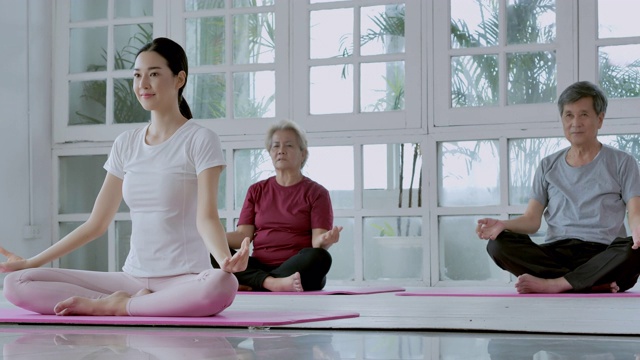 亚洲多代同堂的家庭做瑜伽的家庭锻炼。采购产品家庭，生活方式，人，多代人，老年人，假期，关系，孩子，退休，健康护理，领导，老年人在体育概念。