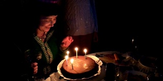 成熟的成年白人女性吹灭生日蛋糕上的蜡烛。