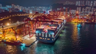 4K Time Lapse或Hyper Lapse:货柜货轮在码头商埠或货柜仓库，在夜间以香港城市景观进行商业物流、进出口、航运或运输。视频素材模板下载