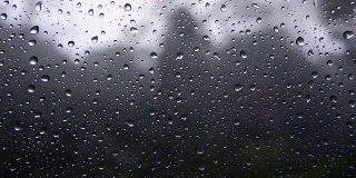 雨点落在在野外行驶的玻璃车上