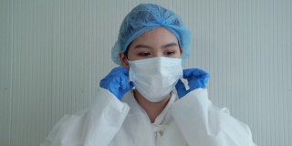 在新冠肺炎疫情中，美丽的亚洲医生摘掉了口罩，在治疗成功后露出了喜悦的笑容。