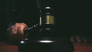 法官在法庭上击打小木槌，黑暗背景慢镜头拍摄视频素材模板下载