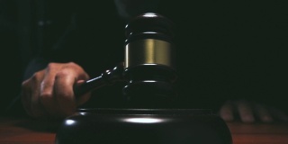 法官在法庭上击打小木槌，黑暗背景慢镜头拍摄