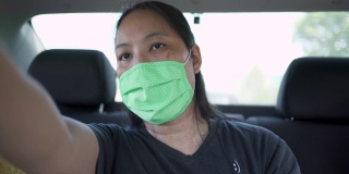 女乘客戴着口罩在出租车上告诉司机该怎么走