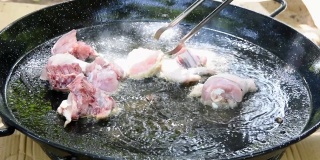 西班牙海鲜饭的制作过程，用滚烫的橄榄油在平底锅里煎兔肉
