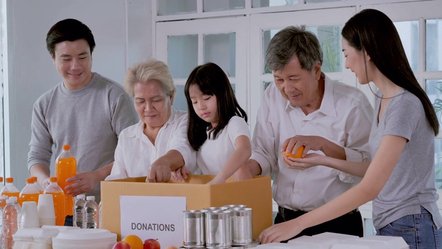 亚洲家庭的志愿者为无家可归的人打包食物和饮料捐赠。教/学捐款的概念。东南亚及东亚:50岁以上人士