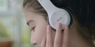 新冠肺炎疫情发生后，一名年轻的亚洲女性在被隔离期间，手持平板电子设备在家听音乐，在温室的小花园中放松，概念简单