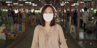 亚洲妇女戴着白布口罩，在新冠肺炎疫情中微笑