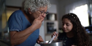 奶奶在家里和孙女一起做巧克力