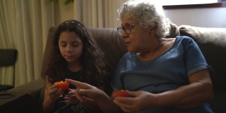 奶奶和孙女在家吃柿子