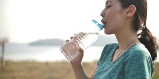 运动女人看智能手表和饮用水