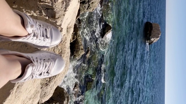 在岩石海滩上的脚视图